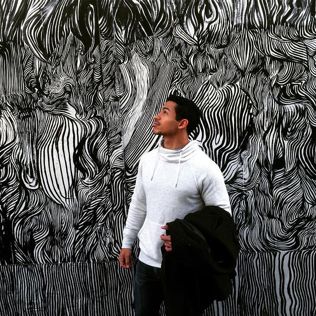 Noah Gray-Cabey in s a white hoodie and black pants.